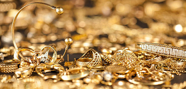 Table of scrap gold being inspected.Focal point on the two bracelets.